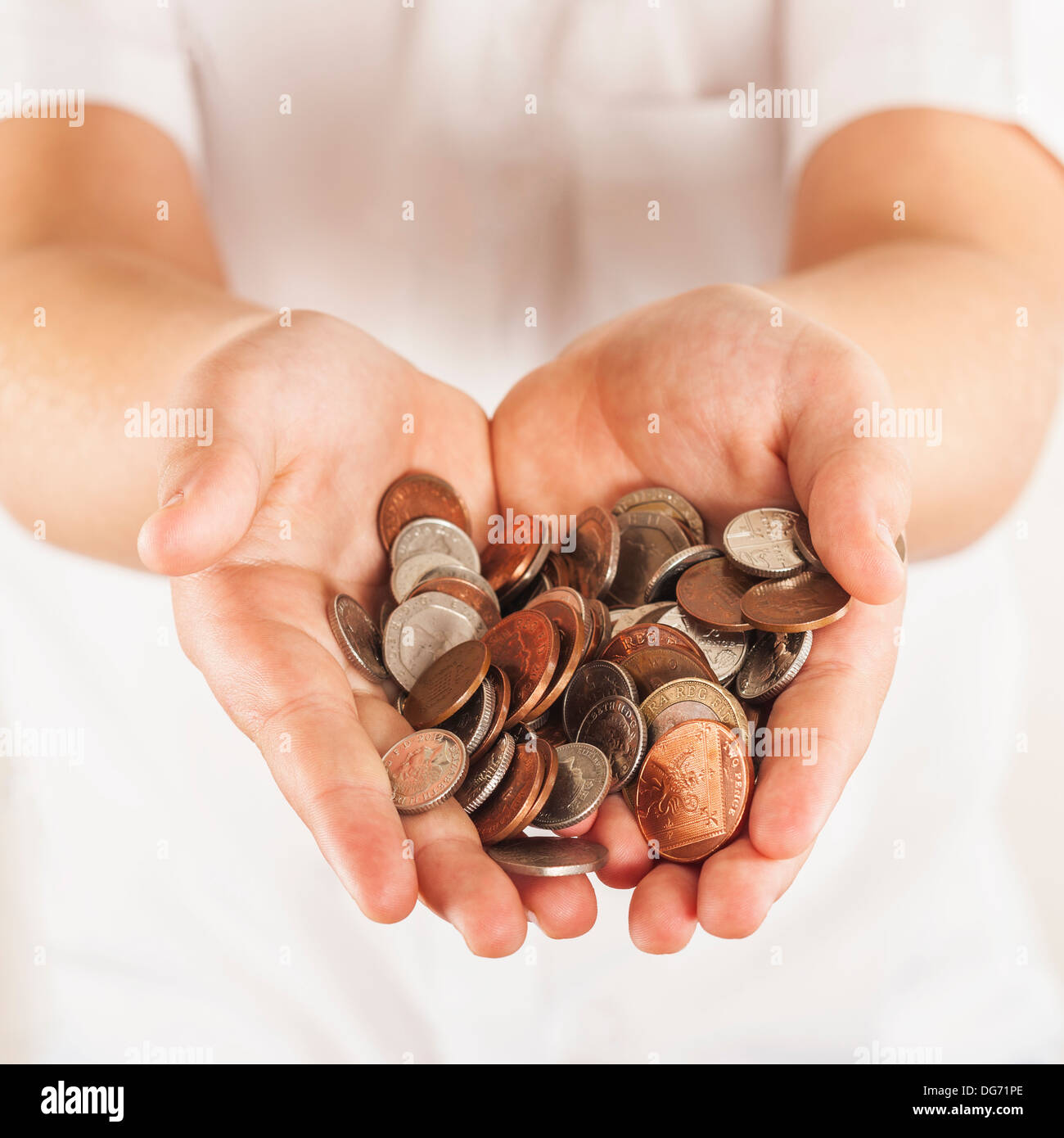 Hände voll Kleingeld in englischer Währung Stockfoto