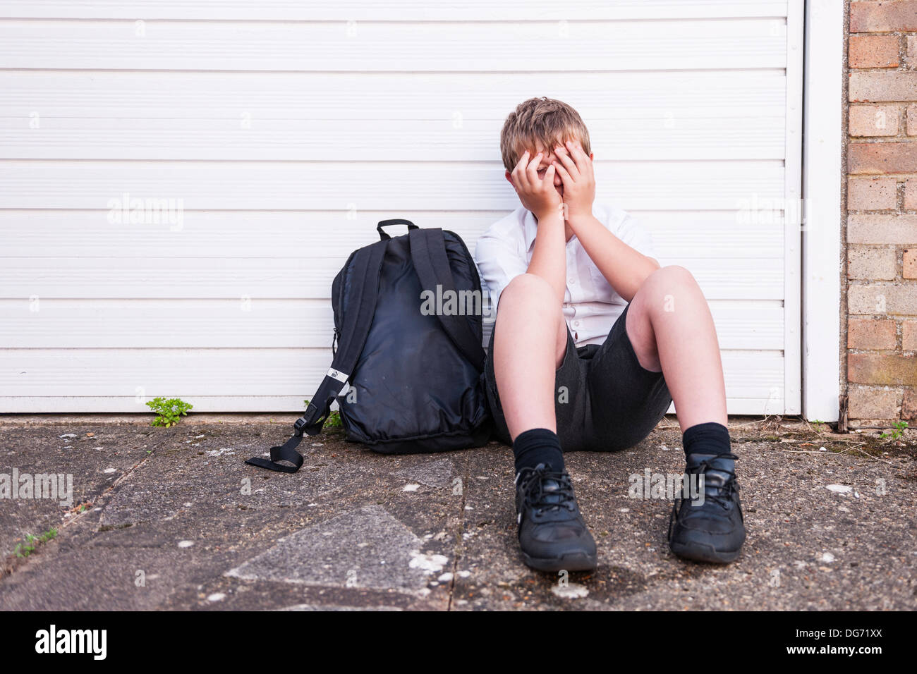 Ein Junge von 10 suchen Sie traurig und deprimiert in seiner Schuluniform zeigt die Auswirkungen von Mobbing im Vereinigten Königreich Stockfoto