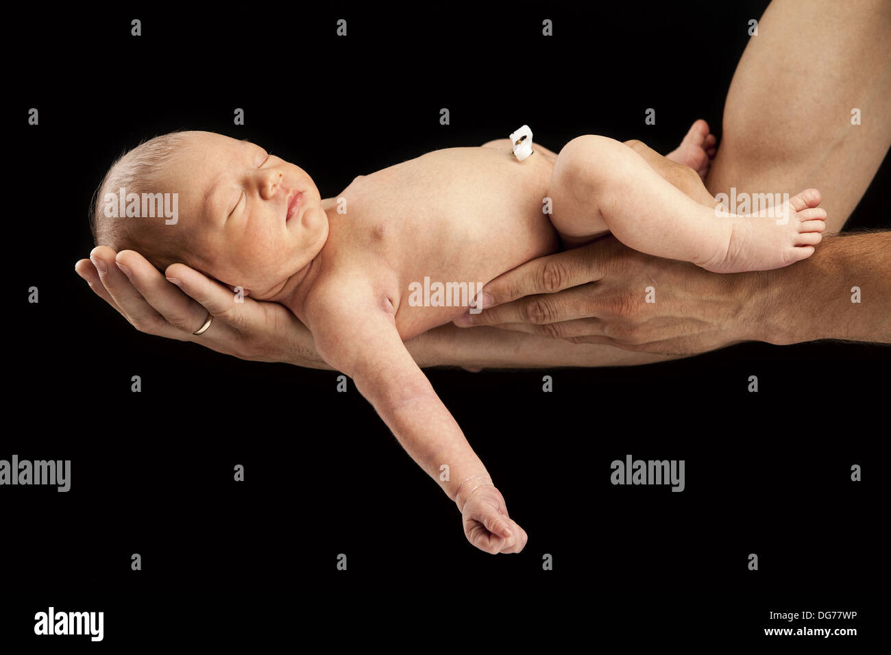 Neugeborenen jungen liegen auf seines Vaters Arme über schwarz Stockfoto