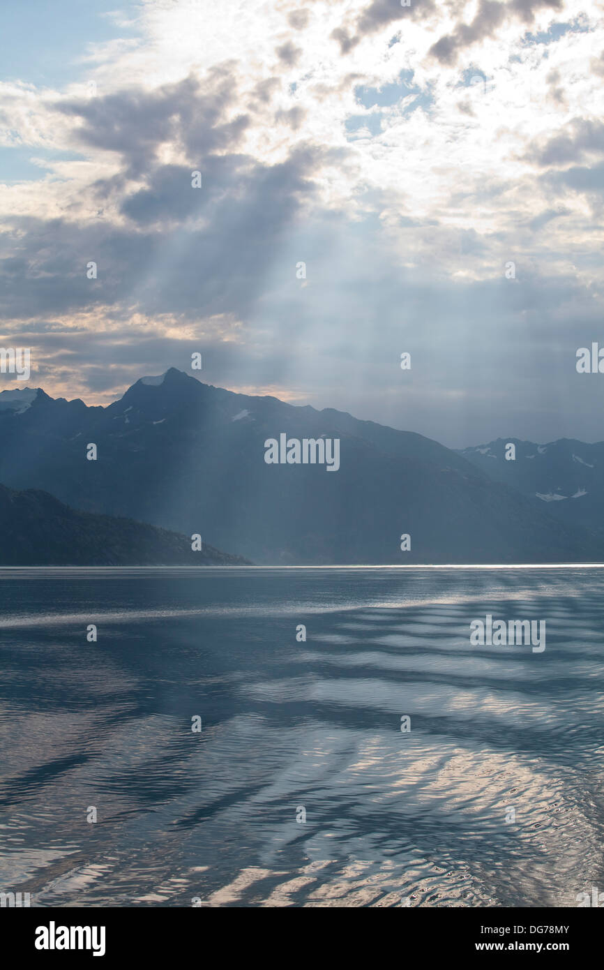 Sonnenlicht durch Wolken in Glacier Bay in Alaska während eine Alaska-Kreuzfahrt strömen. Stockfoto
