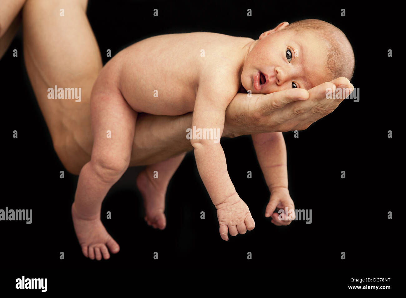 Neugeborenen Jungen am Arm seines Vaters über schwarzen Hintergrund liegen Stockfoto