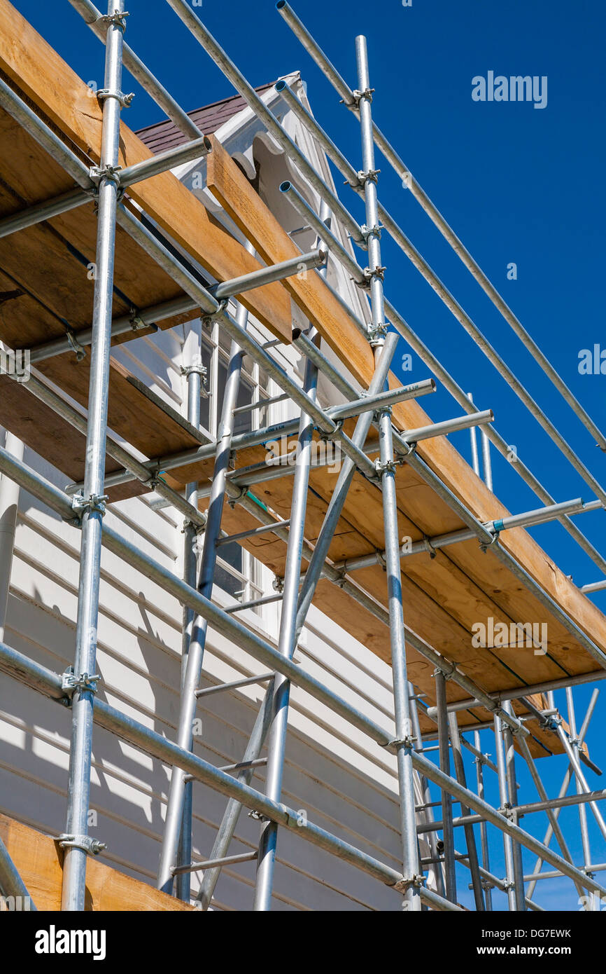 Einem niedrigen Winkel Blick auf Gerüst gegen ein zweistöckiges Gebäude in Reparaturen und Renovierungen. Stockfoto