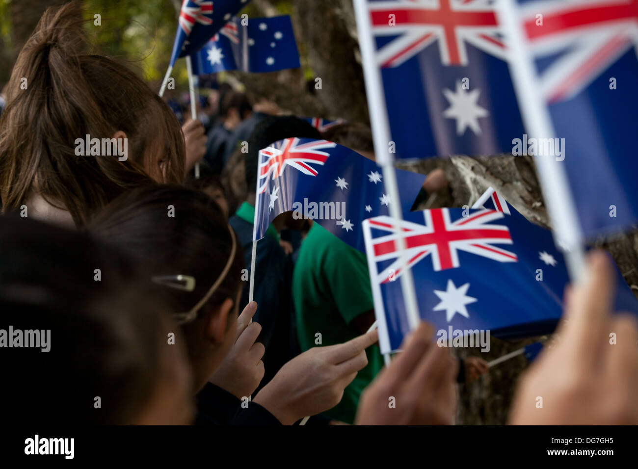 Kinder winken die australische Flagge bei ANZAC Tag Trauerfeier Stockfoto
