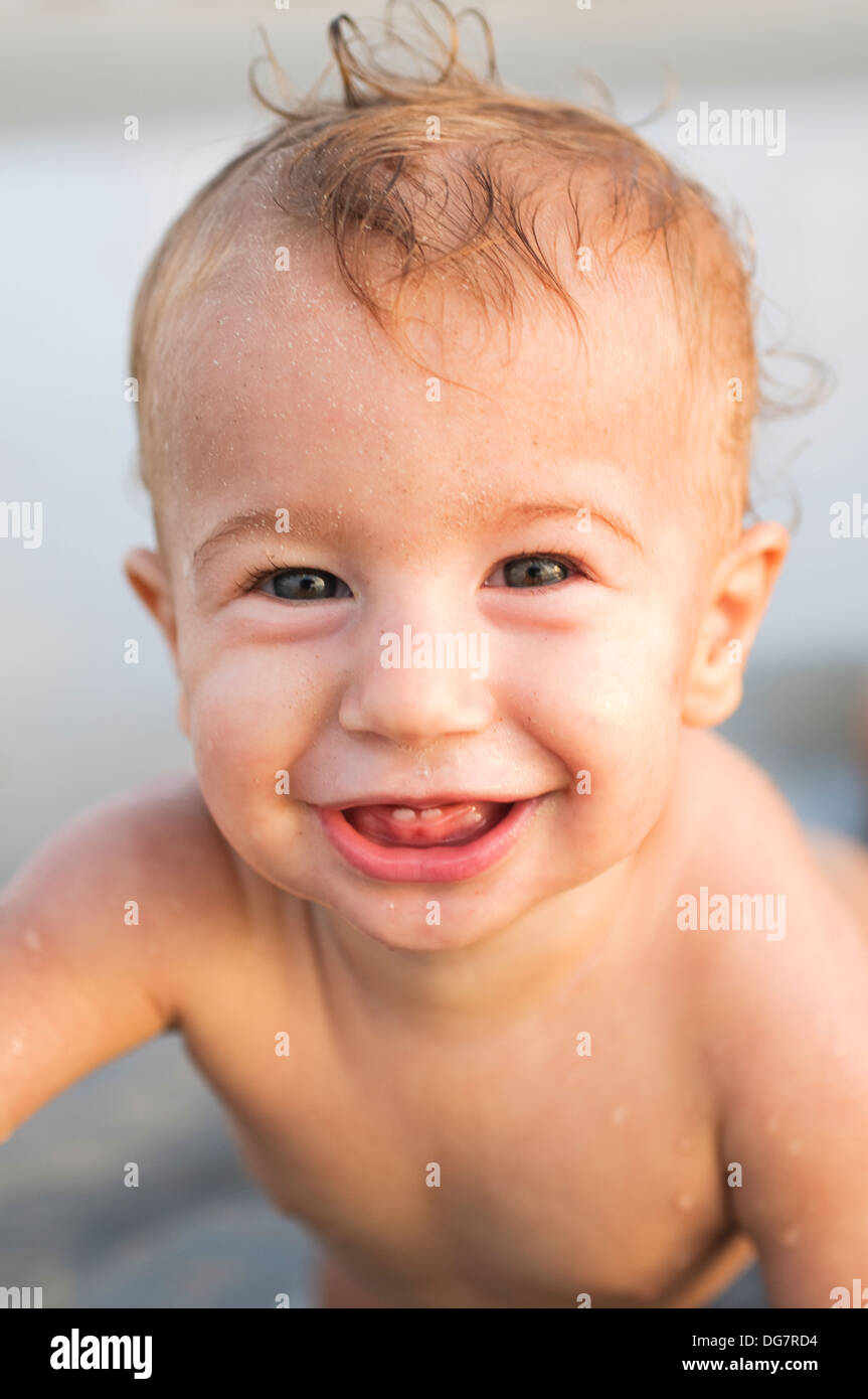 ein glückliches Lächeln auf den Lippen 8 Monate Baby am Strand. Model-Release verfügbar Stockfoto