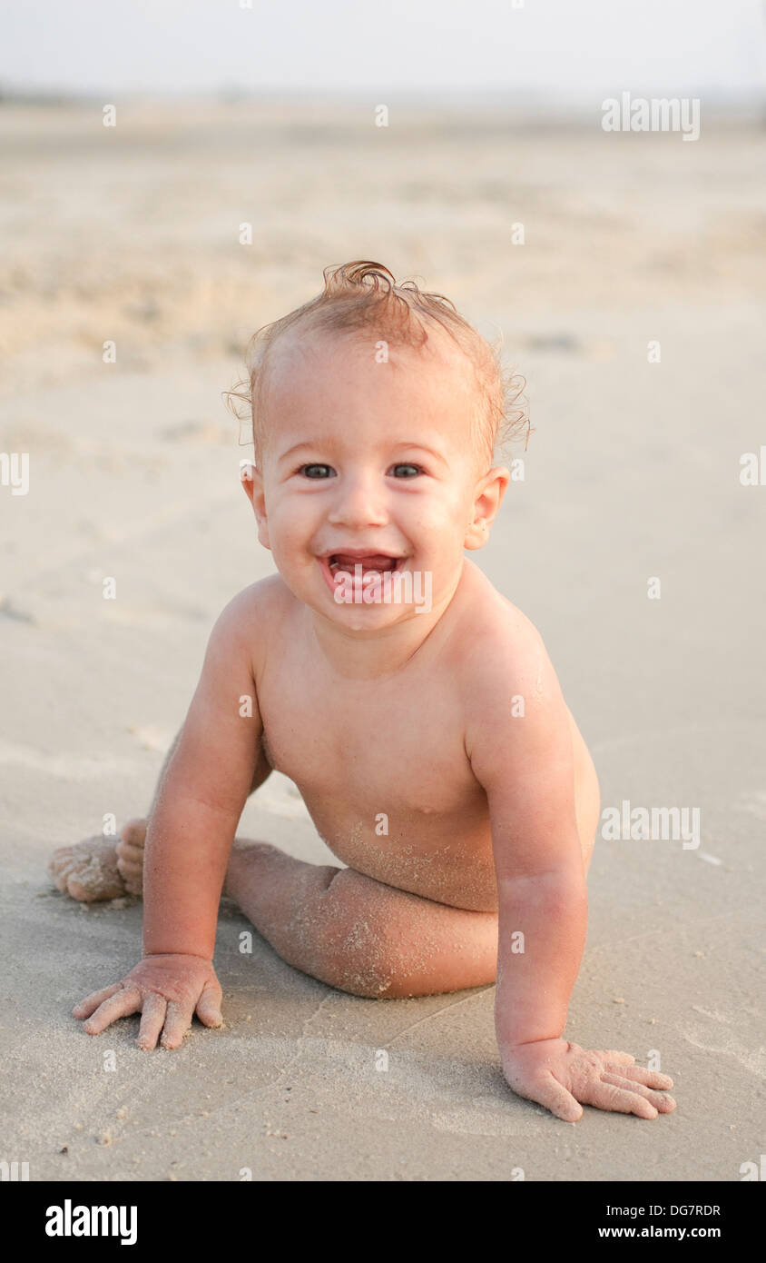 ein glückliches Lächeln auf den Lippen 8 Monate Baby am Strand. Model-Release verfügbar Stockfoto