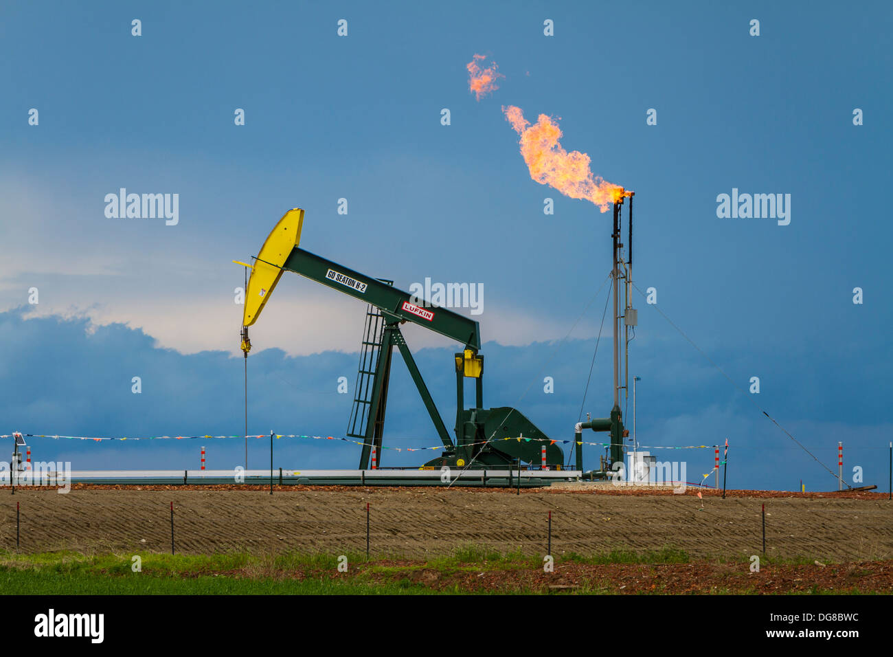 Abfackeln von Erdgas und ein Löschfahrzeug in den Bakken Shale Ölfeldern in der Nähe von Williston, North Dakota, USA. Stockfoto