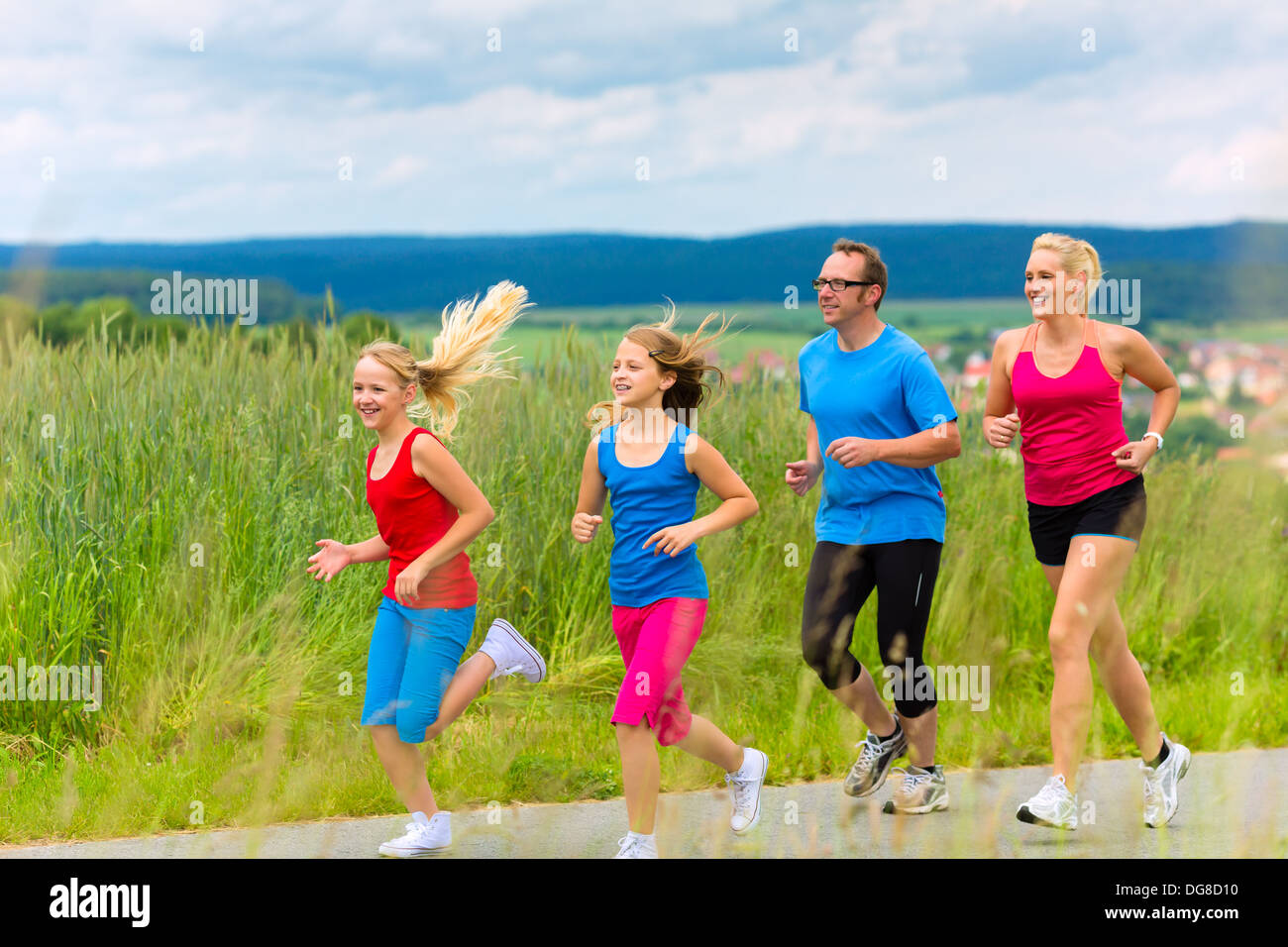 Familie - Mutter, Vater und vier Kinder - jogging oder Outdoor-Sport für Fitness auf ländliche Straße Stockfoto