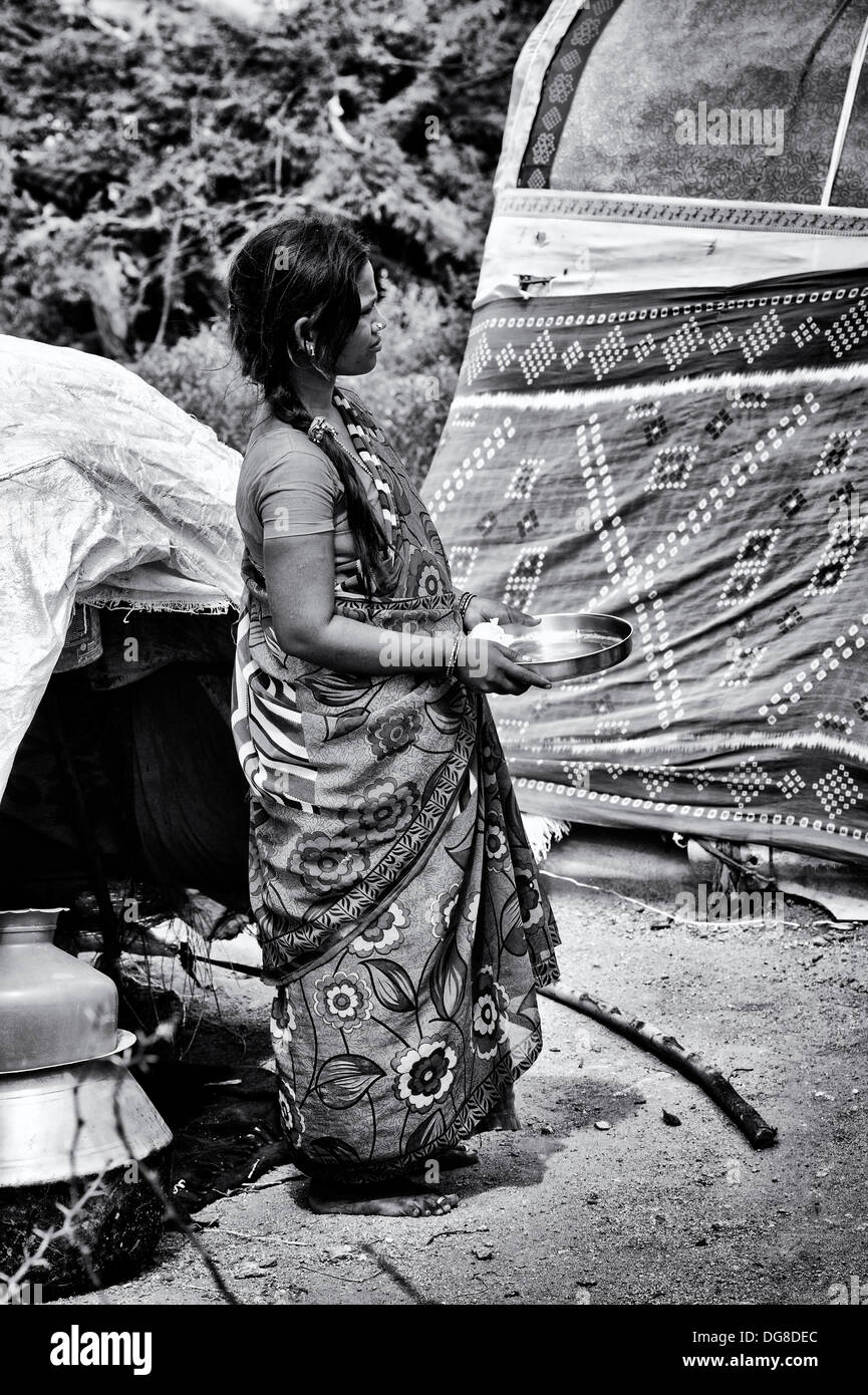 Niedrigere Kaste indische schwangere Teenager-Mädchen warten auf freie Nahrung und Kleidung vor ihrem Zelt Haus erhalten. Andhra Pradesh, Indien Stockfoto