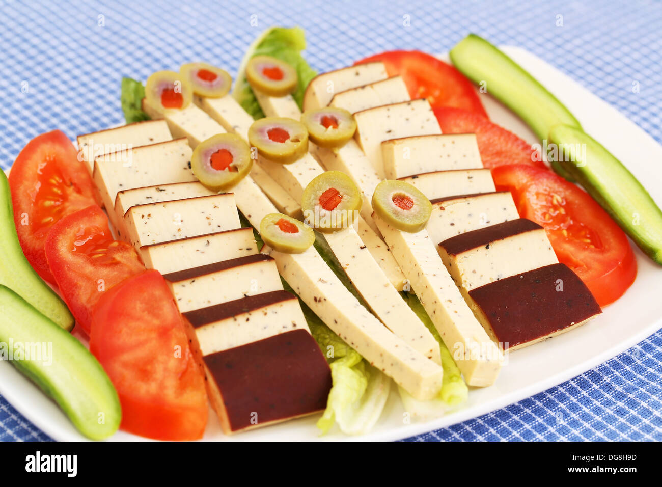 Käse, Oliven und Gemüse auf Teller. Stockfoto