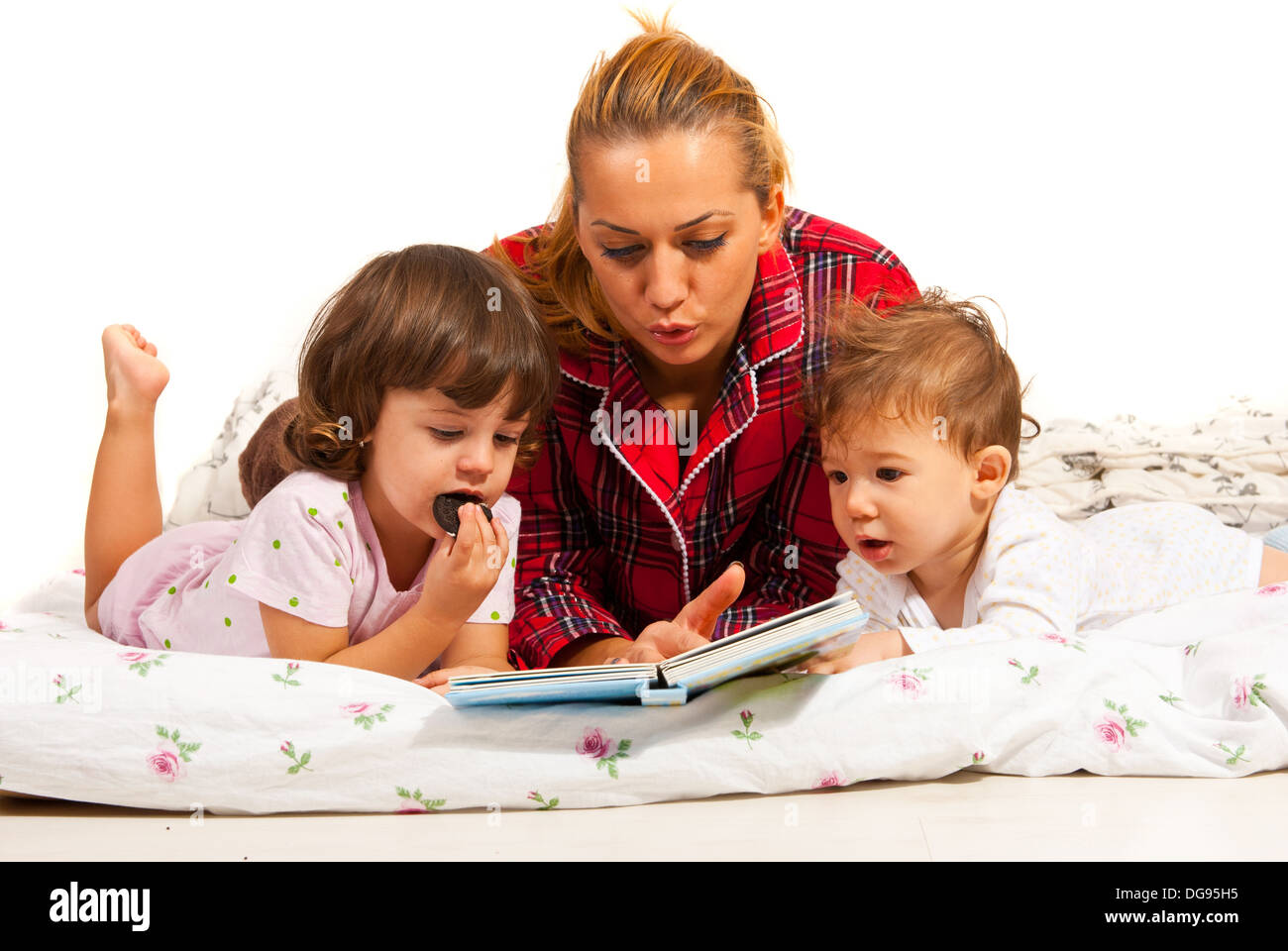 Mutter Lesung Gutenachtgeschichte ihre Kinder im Bett Stockfoto