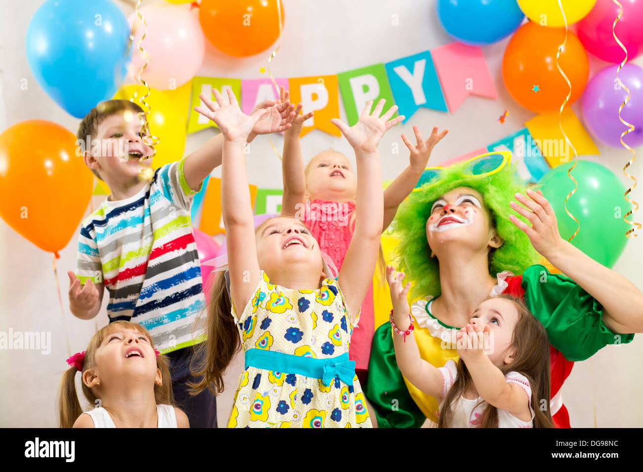 fröhliche Kinder Gruppe mit Clown feiert Geburtstag Stockfoto