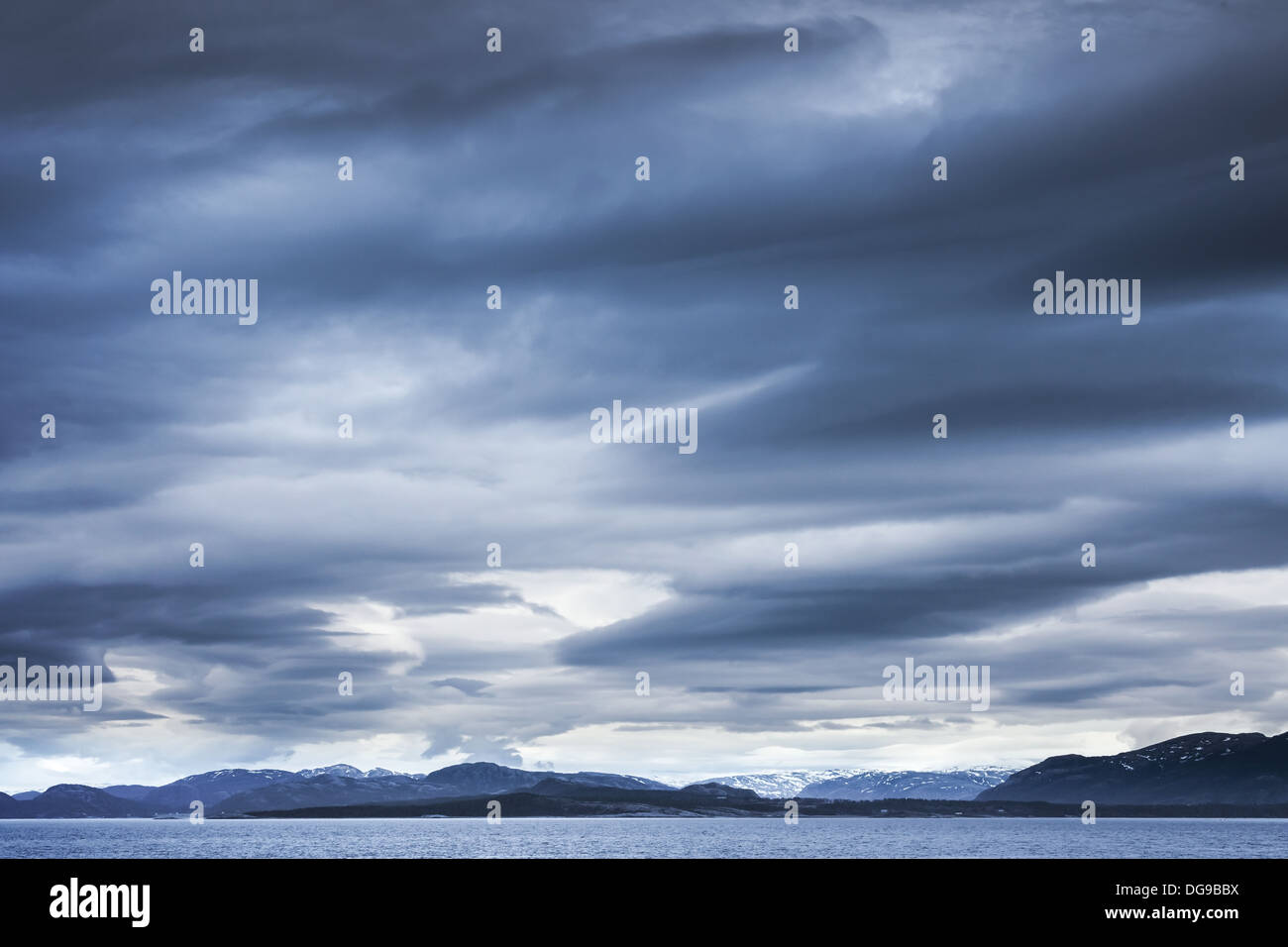 Dunkel blau stürmischen Wolken über den Bergen. Leere norwegischen See Landschaft Stockfoto