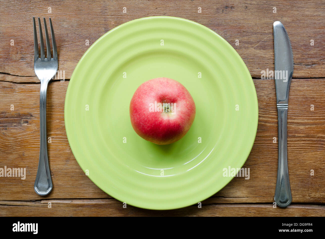 saftige rote Apfel auf die grüne Platte mit Vintage Holztisch Hintergrund Stockfoto