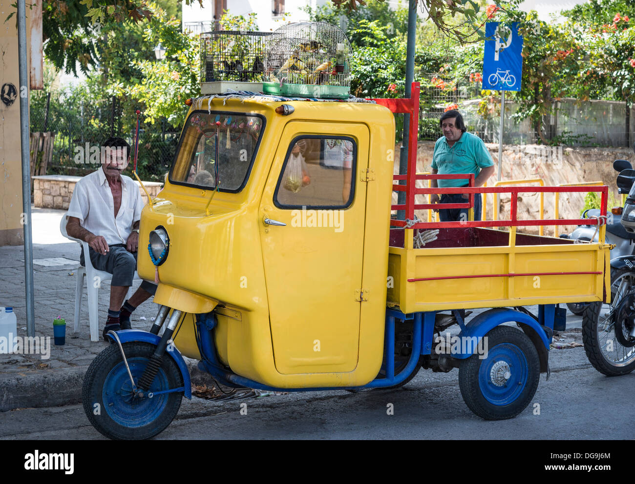 Mann verkaufen Käfig Vögel von oben auf seine Vintage Dreirad in Kalamata Markt, Messinia, Peloponnes, Griechenland Stockfoto