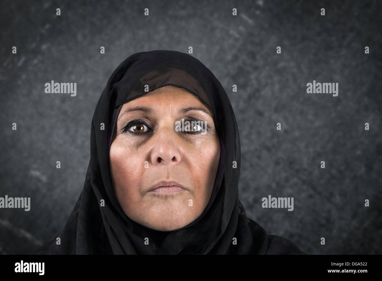 Dramatische Porträt von Ernst mittleren gealterten Muslimin mit schwarzen Schal oder hijab Stockfoto