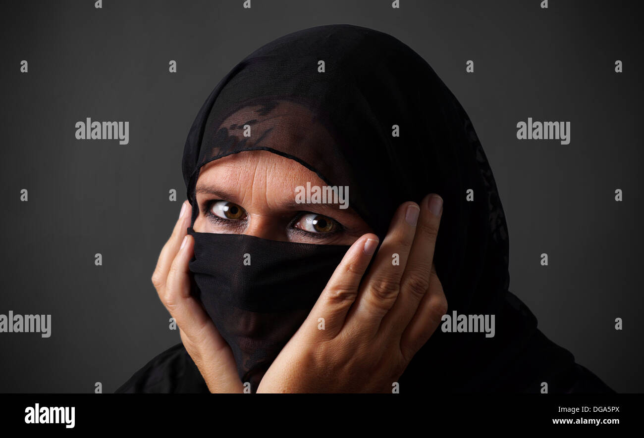 Muslimische Frau mittleren Alters, versteckt ihr Gesicht schauen böse Stockfoto