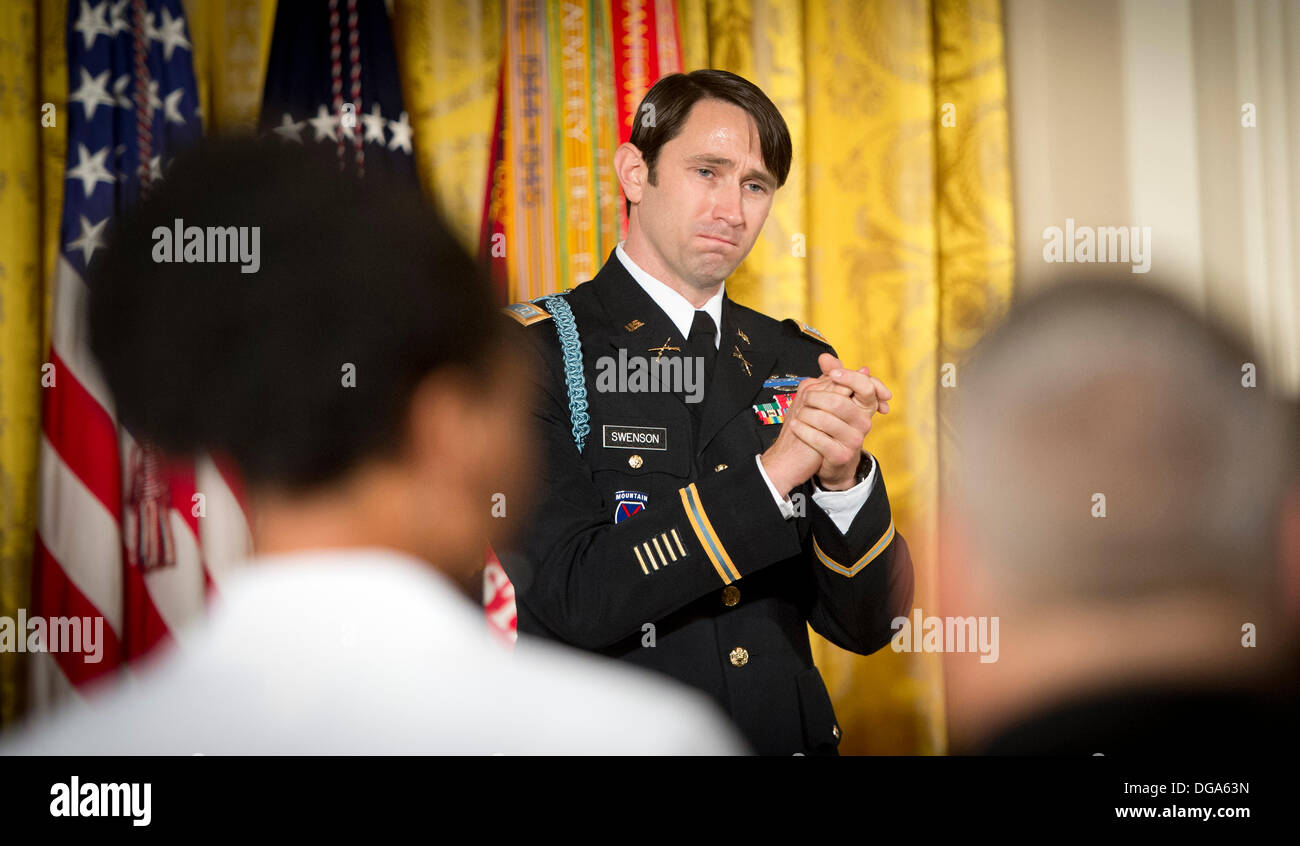 US Army Captain William D. Swenson reißt, wie er die gefallenen und verwundeten Kameraden, die er begrüßt neben mit in Afghanistan während seiner Medal Of Honor-Zeremonie im East Room des weißen Hauses 15. Oktober 2013 in Washington, D.C. gekämpft. Die Medal Of Honor ist die höchste militärische Auszeichnung des Landes. Stockfoto