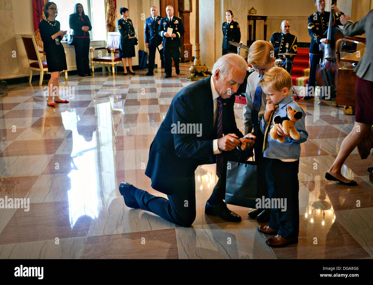 US-Vizepräsident Joe Biden Hände Kinder ausgestopfte Tiere während der Medal Of Honor-Zeremonie im Weißen Haus 15. Oktober 2013 in Washington, DC. Die Medal Of Honor ist die höchste militärische Auszeichnung des Landes. Stockfoto