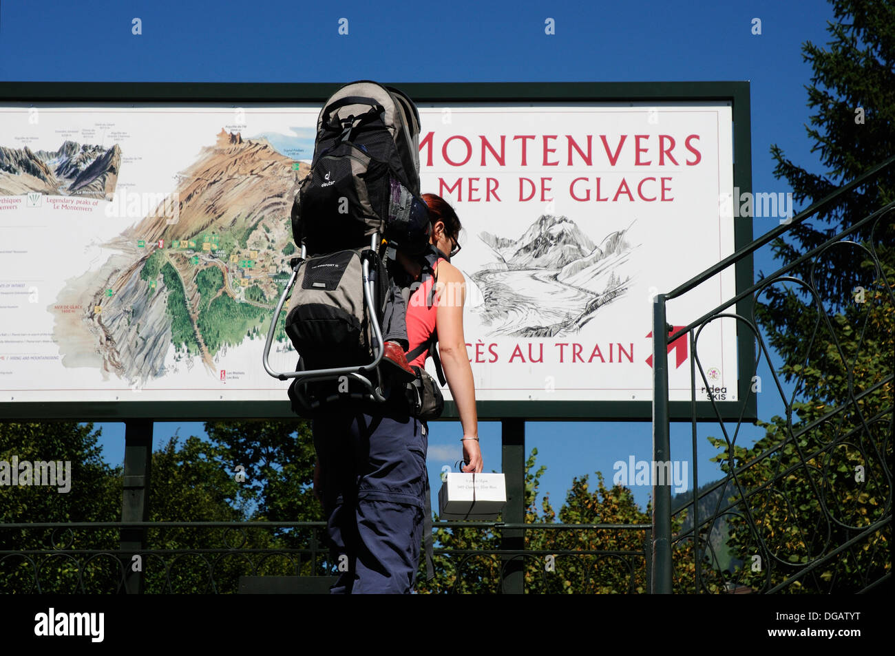 Eine Frau mit Har Baby im Tragetuch vorbei das Zeichen für die Montenvers-Standseilbahn Stockfoto