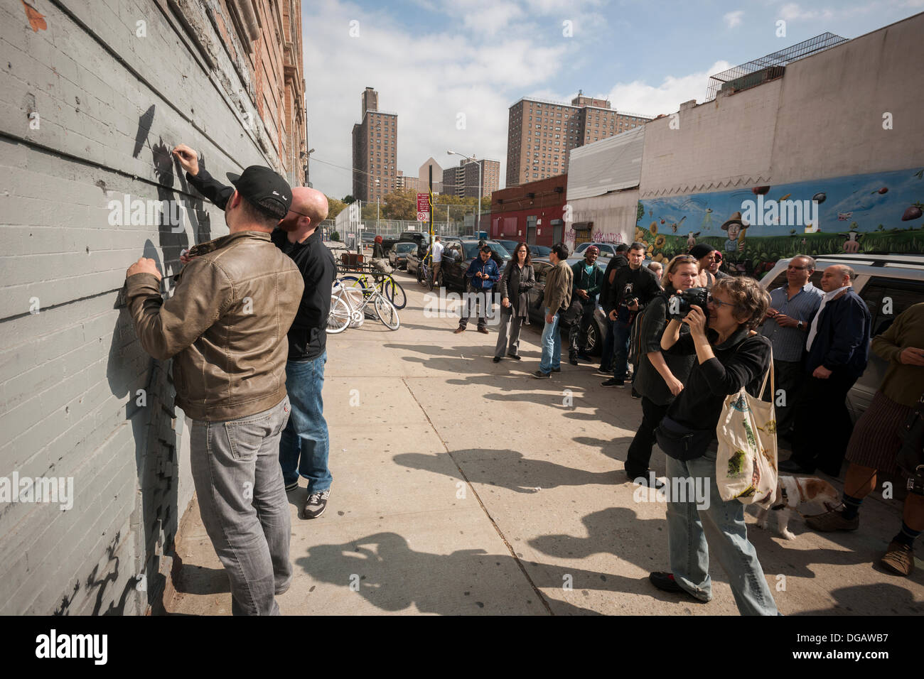 New York, USA. 17. Oktober 2013. Street-Art-Enthusiasten inspizieren und reinigen Schaden durch Vandalen in der siebzehnten Ausgabe von Banksy-Graffiti-Kunst im Stadtteil Williamsburg in Brooklyn in New York auf Donnerstag, 17. Oktober 2013.  Die schwer fassbare Streetart-Künstler schafft Werke rund um die Stadt jeden Tag im Laufe des Monats Oktober.   Bildnachweis: Richard B. Levine/Alamy Live-Nachrichten) Stockfoto