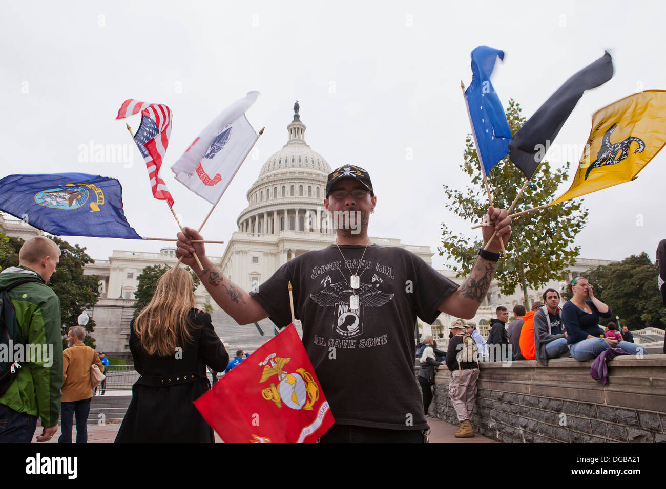 Mann winken U.S. militärische Fahnen vor dem US Capitol Gebäude - Washington, DC USA Stockfoto