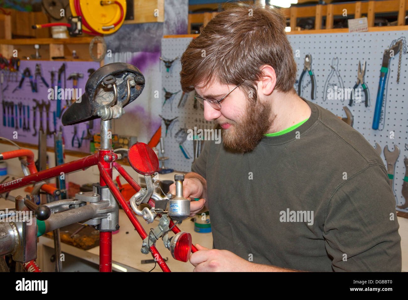 Teen mit Bart Reparatur Fahrrad im Non-Profit-Jugend Express Fahrradwerkstatt. St Paul Minnesota MN USA Stockfoto