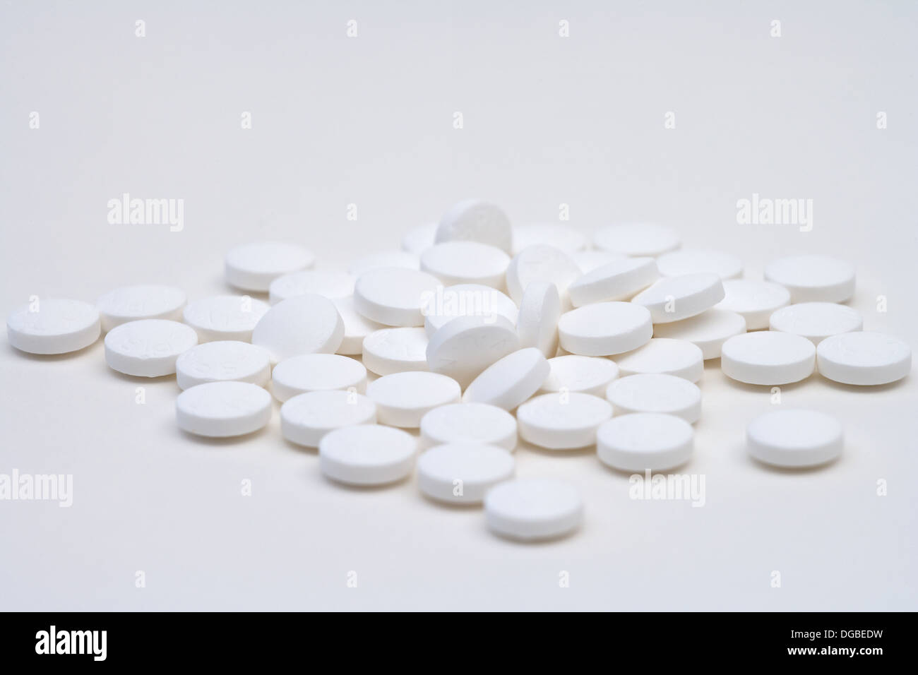 Reihe von losen weißen Aspirin-Tabletten auf weißem Hintergrund Stockfoto