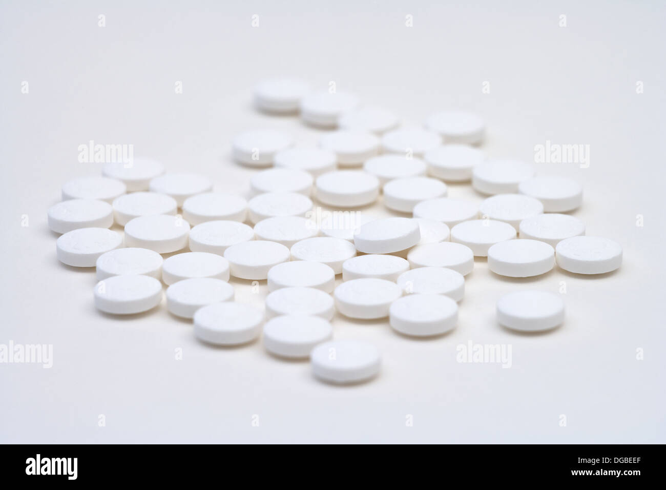 Reihe von losen weißen Aspirin-Tabletten auf weißem Hintergrund Stockfoto