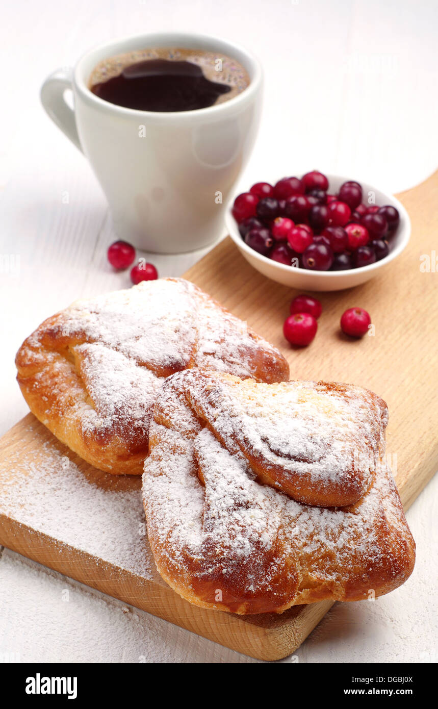 Brötchen mit Kaffee und Preiselbeeren auf ein Schneidebrett Stockfoto