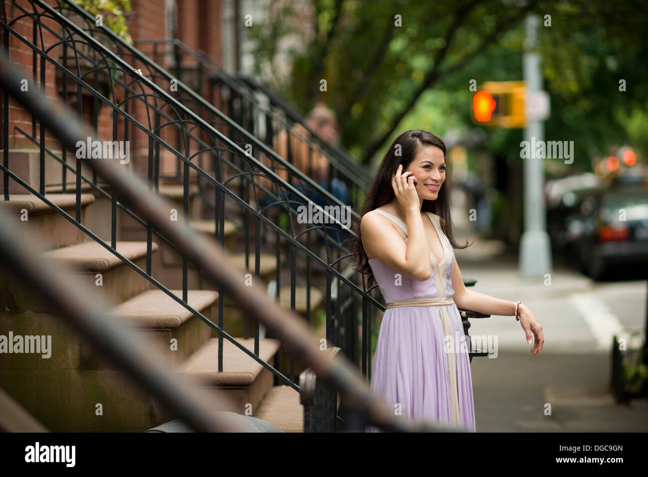 Mitte Erwachsene Frauen mit Handy von Brownstone Gebäude in Greenwich, New York Stockfoto