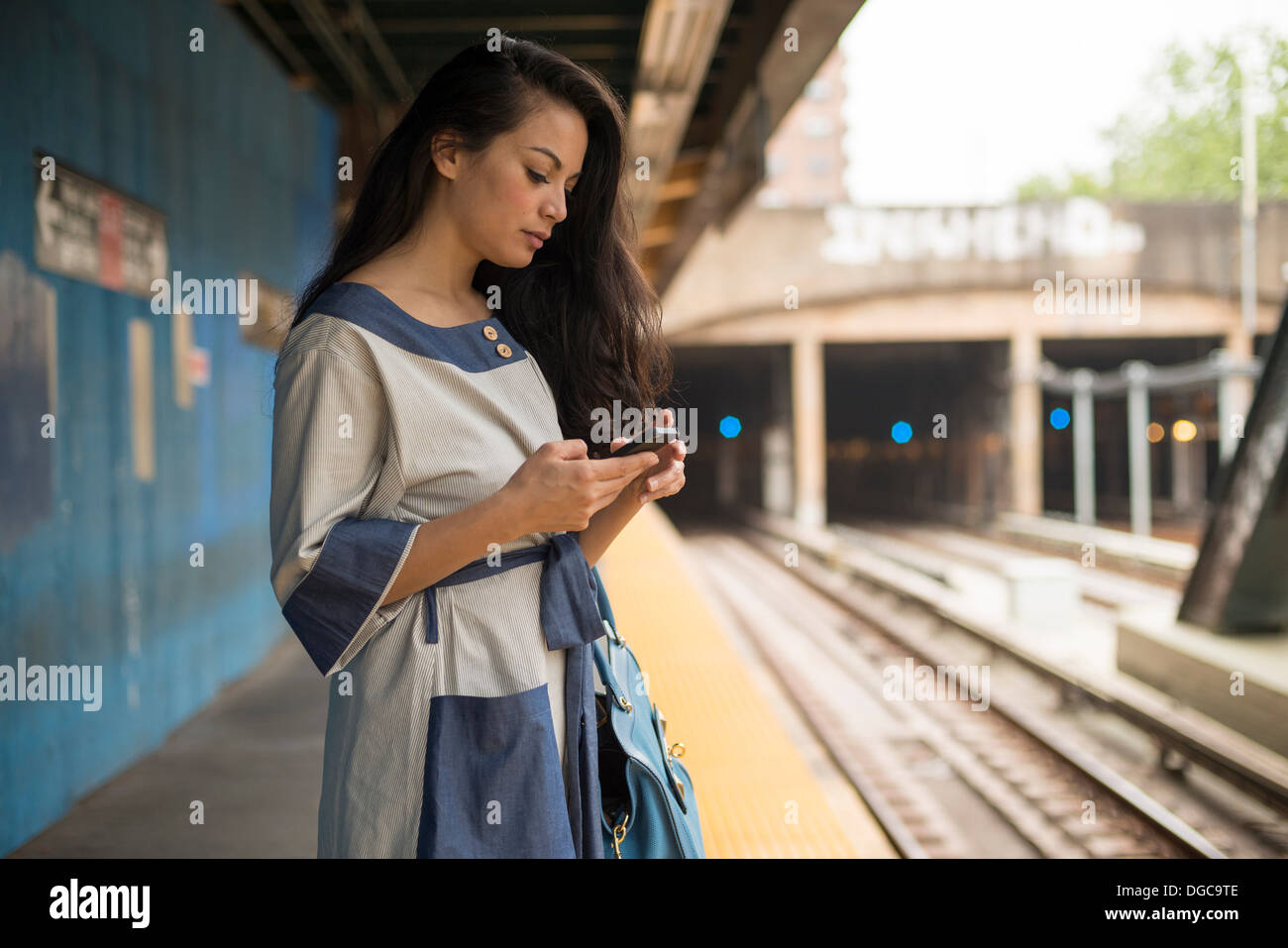 Mitte Erwachsene Frauen mit Handy auf u-Bahn-Plattform, Brooklyn, New York Stockfoto