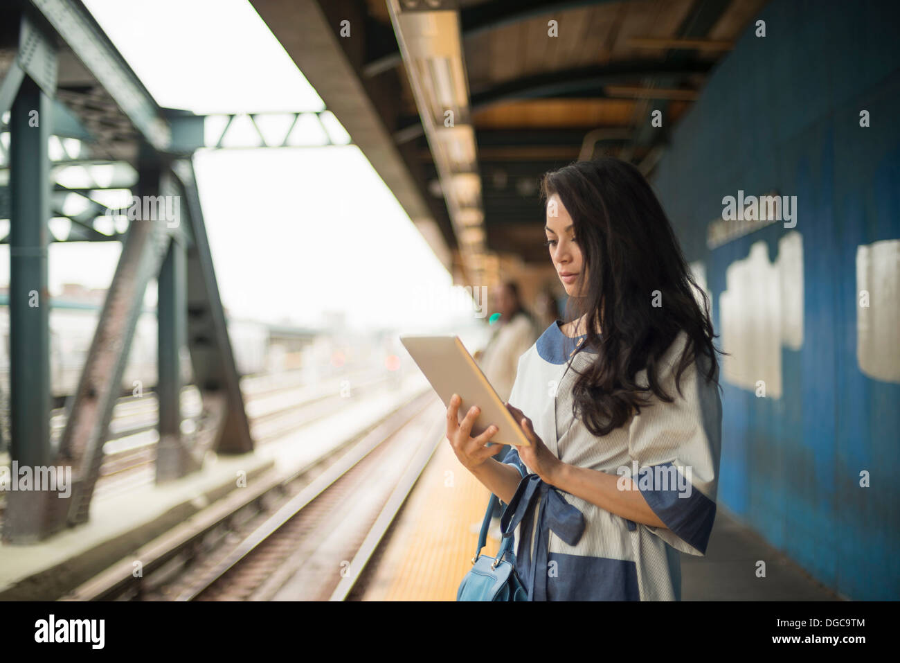 Mitte Erwachsene Frauen mit digital-Tablette auf u-Bahn-Plattform, Brooklyn, New York Stockfoto