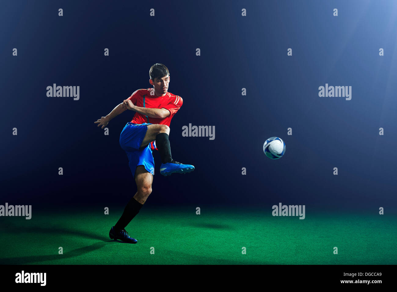 Junge männliche Fußballspieler treten ball Stockfoto