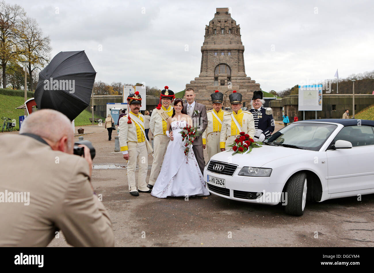 Leipzig, Deutschland. 18. Oktober 2013. Das Brautpaar Maria und Michael Steudel posieren für ihr Hochzeitsfoto inmitten historisch gekleideten Soldaten vor der Schlacht der Nationen-Denkmal in Leipzig, Deutschland, 18. Oktober 2013. Auf Sonntag, 20. Oktober 2013 werden mehr als 6.000 Teilnehmer die Schlacht von 1813 zwischen den Armeen der Russland, Preußen, Österreich und Schweden nachspielen. Der Kampf der Nationen, kämpften 16 bis 19. Oktober 1813, ergab einen Schlüssel von Werkens Truppen besiegt. Foto: JAN WOITAS/Dpa/Alamy Live News Stockfoto