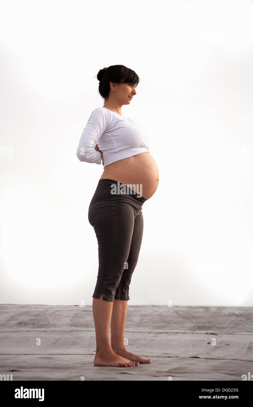 Schwangere Frau in Yoga-Berg-pose Stockfoto