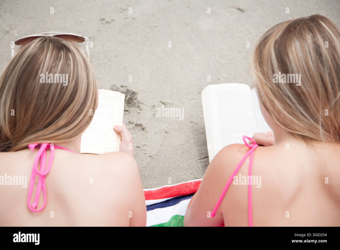 Junge Frauen lesen am Strand Stockfoto