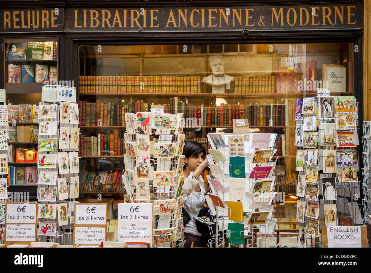 Junge Frau einkaufen bei einem antiken Buchladen in Passage Vivienne, Paris Frankreich Stockfoto