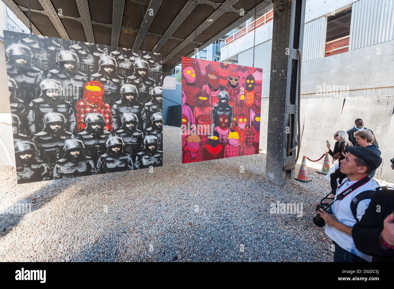 New York, USA. 18. Oktober 2013. Streetart-Fans strömen in West Chelsea Galerie Szeneviertel in New York die 18. Ausgabe von Banksy-Graffiti-Kunst, eine Zusammenarbeit mit den brasilianischen Künstlern, Os Gemeos sehen. Dieser Titel ist wie einer Museumsausstellung in eine Baulücke unter der High Line Park komplett mit "Museumswärter" Gruppenkontrolle behandeln eingerichtet. Die schwer fassbare Streetart-Künstler schafft Werke rund um die Stadt jeden Tag im Laufe des Monats Oktober. Bildnachweis: Richard Levine/Alamy Live-Nachrichten Stockfoto