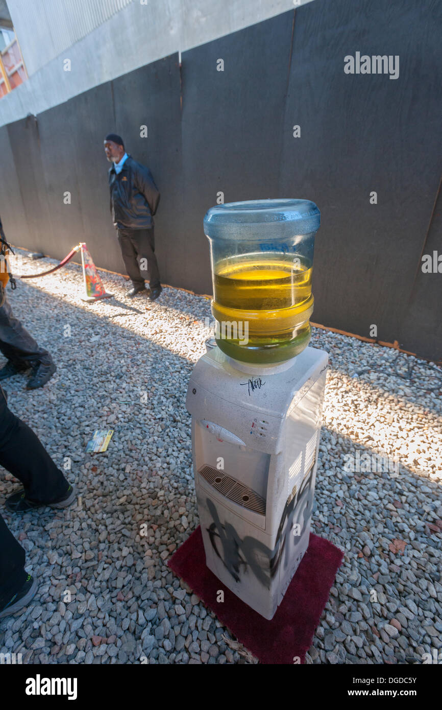 New York, USA. 18. Oktober 2013. Ein Wasserspender dient "Erfrischungen" im trendigen West Chelsea Gallery District in New York im Rahmen der 18. Ausgabe von Banksy-Graffiti-Kunst, eine Zusammenarbeit mit den brasilianischen Künstlern, Os Gemeos. Dieser Titel ist wie einer Museumsausstellung in eine Baulücke unter der High Line Park komplett mit "Museumswärter" Gruppenkontrolle behandeln eingerichtet. Die schwer fassbare Streetart-Künstler schafft Werke rund um die Stadt jeden Tag im Laufe des Monats Oktober. Bildnachweis: Richard Levine/Alamy Live-Nachrichten Stockfoto