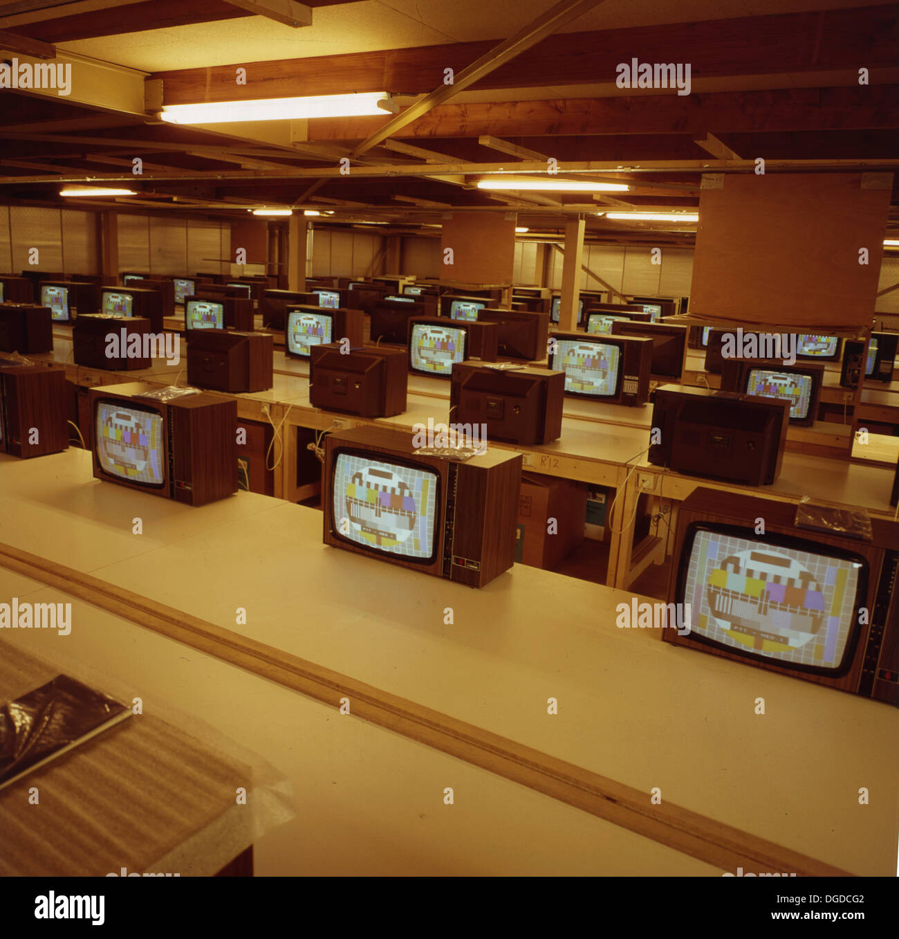 1960er Jahre, Fernseher der Ära, die auf Schreibtischen sitzen und getestet werden, alle zeigen das PM5544:Common PAL Testmuster. Das Testmuster oder die Testkarte wurde angezeigt, als keine Programme gesendet wurden. Stockfoto