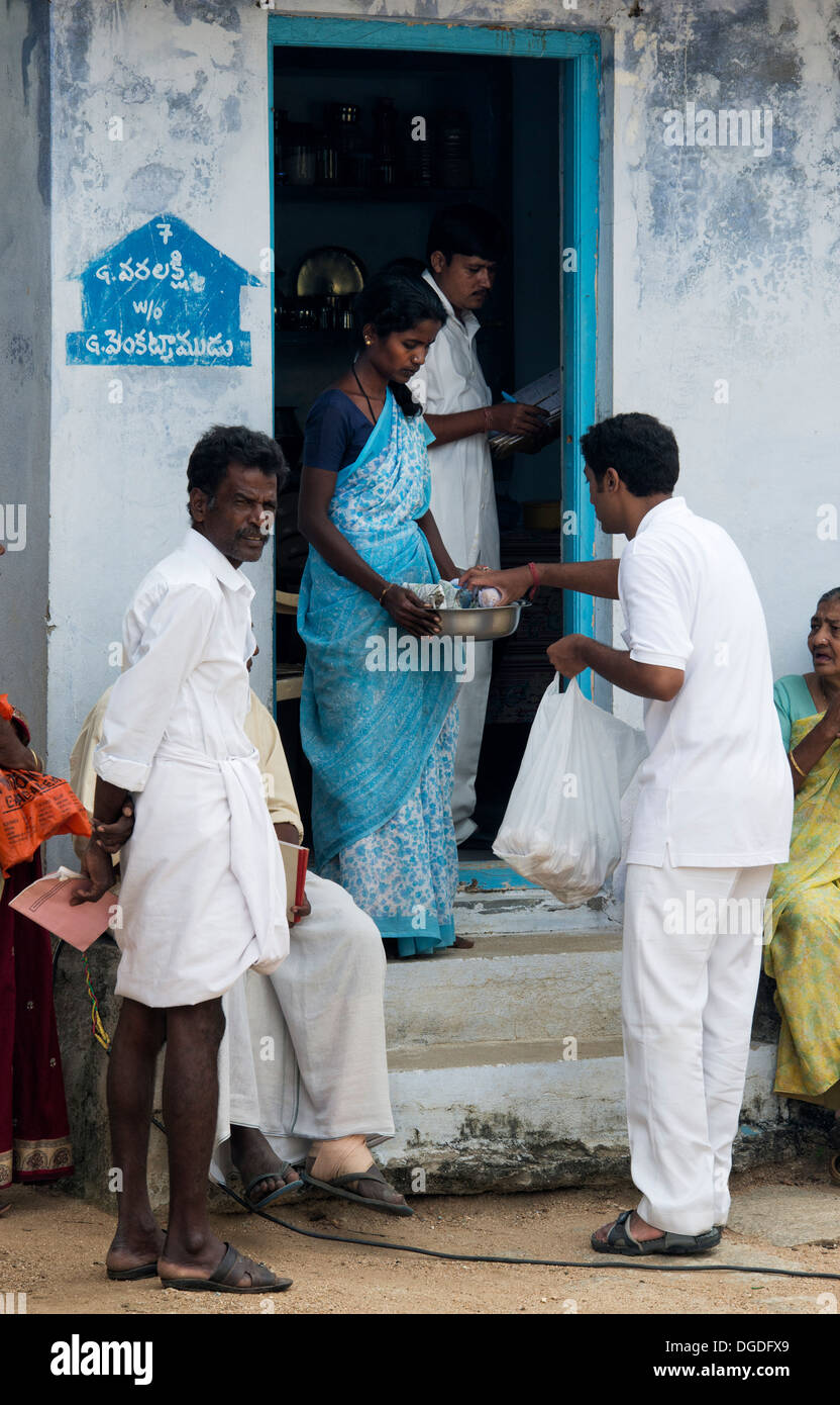 Indischen Sri Sathya Sai Baba College jungen verteilen Lebensmittel-Pakete bei Grama Seva in einem indischen Dorf.  Andhra Pradesh, Indien Stockfoto