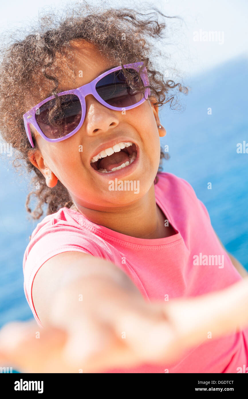 Schöne glückliche Mischlinge afroamerikanische weibliche Mädchen mit Sonnenbrille im Sonnenschein Urlaub mit tropischen Meer Stockfoto