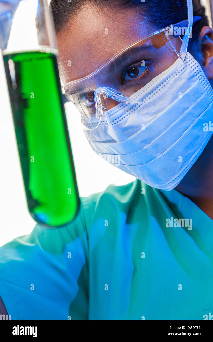 Asiatische medizinische oder wissenschaftliche Forscherin oder Arzt Blick auf ein Reagenzglas grüne Lösung in einem Labor Stockfoto