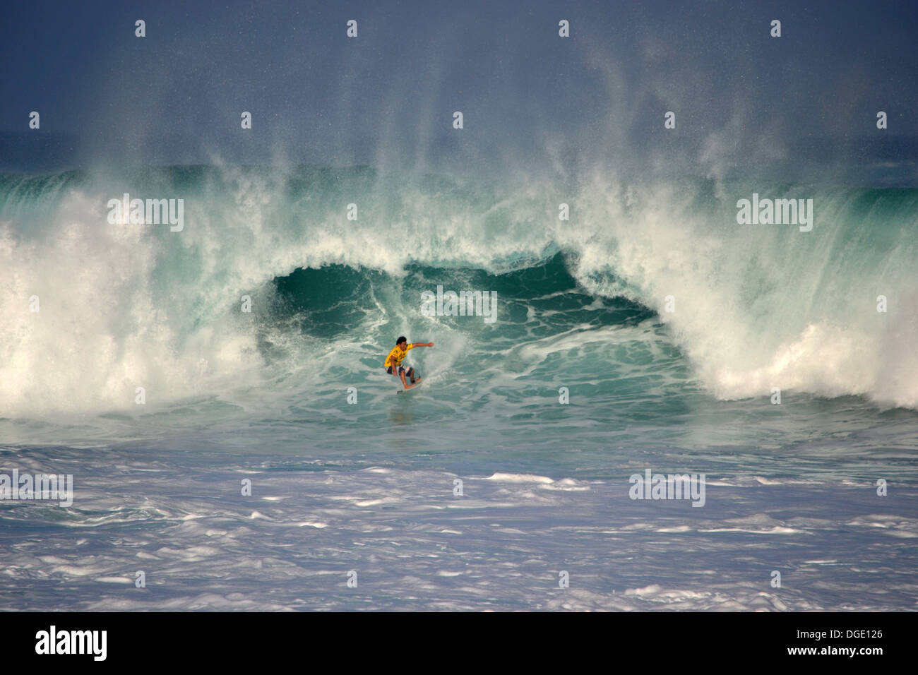 Surfer reitet eine große Welle, Waimea Bay, nördlich von Oahu, Hawaii, USA Stockfoto