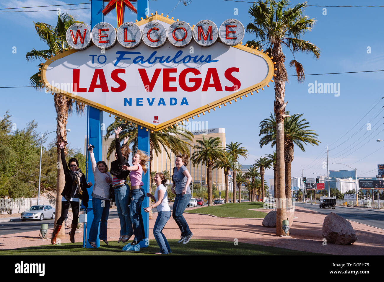 Touristen, die bei der legendären Begrüßung zum fabelhaften Las Vegas Nevada Schild springen Stockfoto