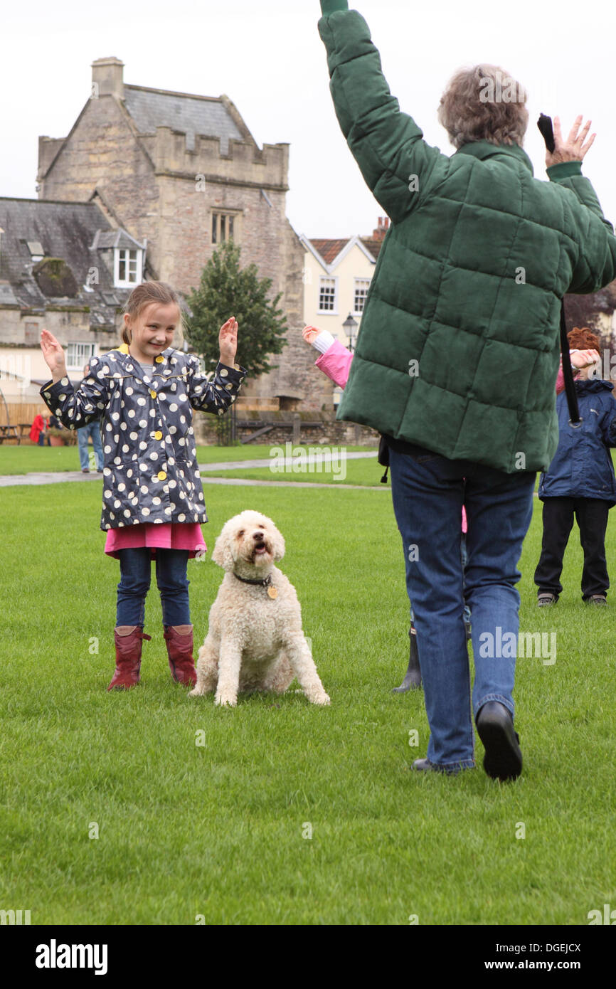 Trainer Marion Dean (in grün) und ihre Langotto-Romagnolo Hund namens Mufti geben eine Demonstration der Trüffelsuche mit jungen Freiwilligen spielt die Rolle der Bäume bei Wells Somerset UK Stockfoto