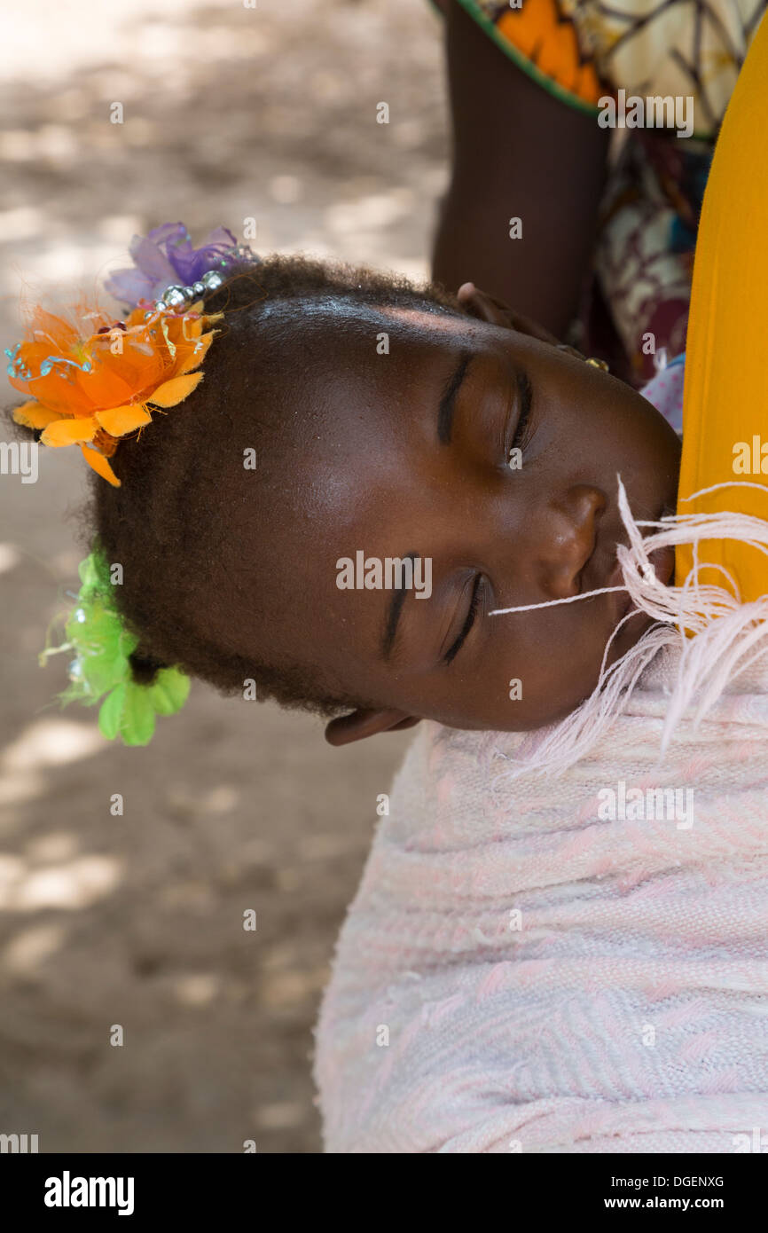 Baby Mädchen schlafen während auf Mutters Rücken, Fass Njaga Choi, North Bank Region, Gambia. Stockfoto