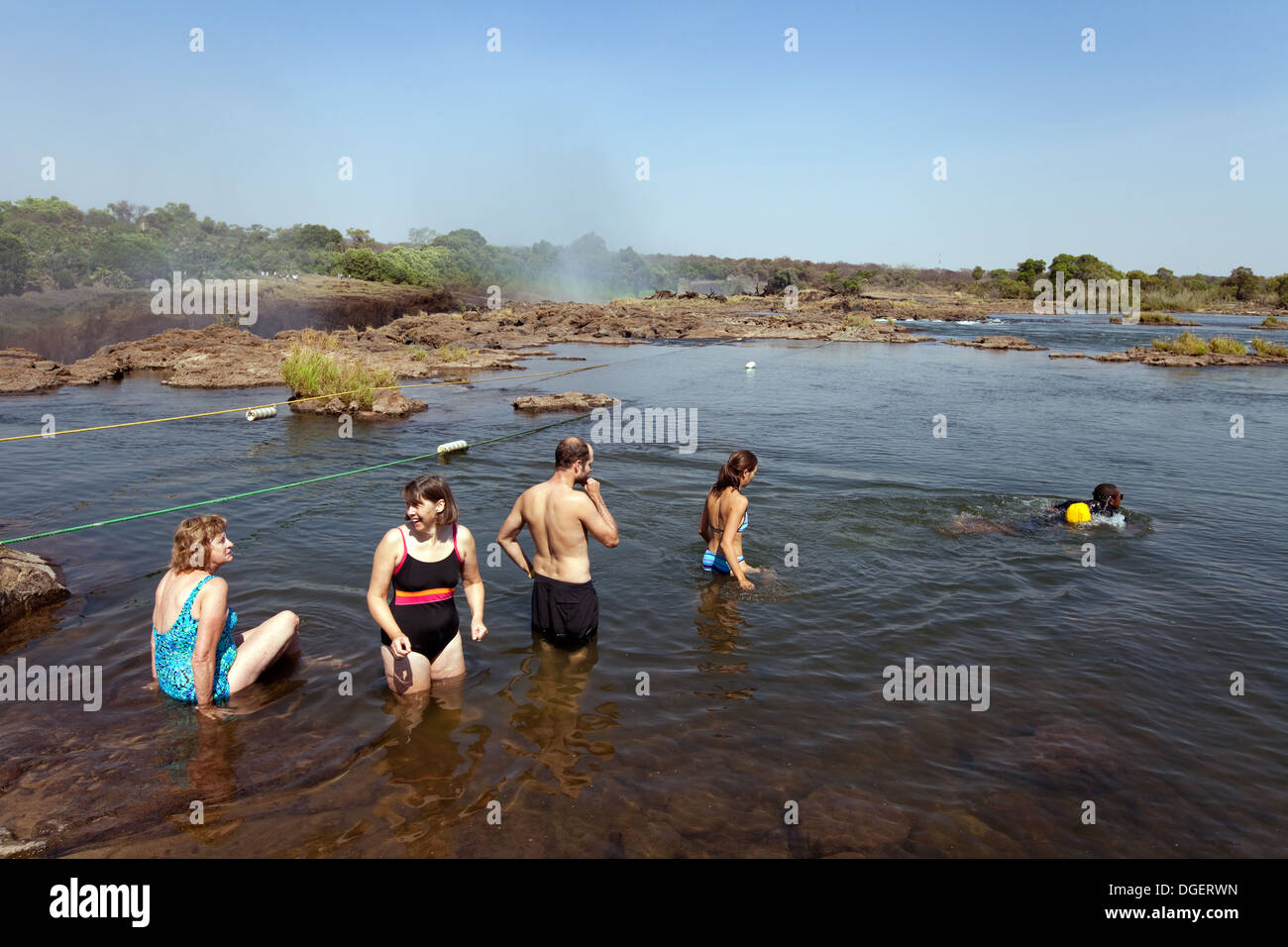Touristen, die schwimmen Devils Pool am Rande der Victoriafälle, Insel Livingstone, Sambia Afrika Stockfoto