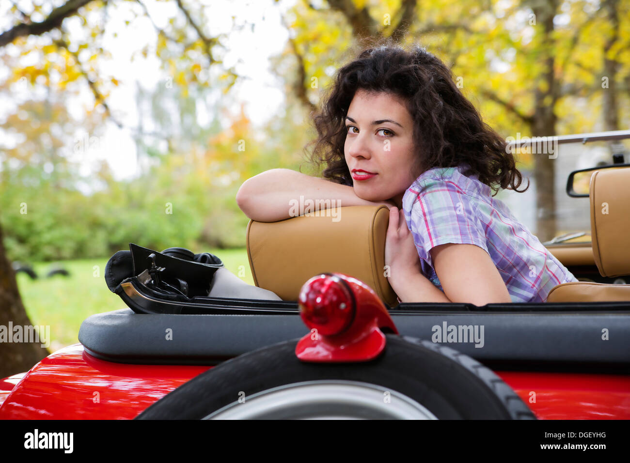 Hübsche Frau Relais Retro-Auto-Kindersitz hinten Stockfoto