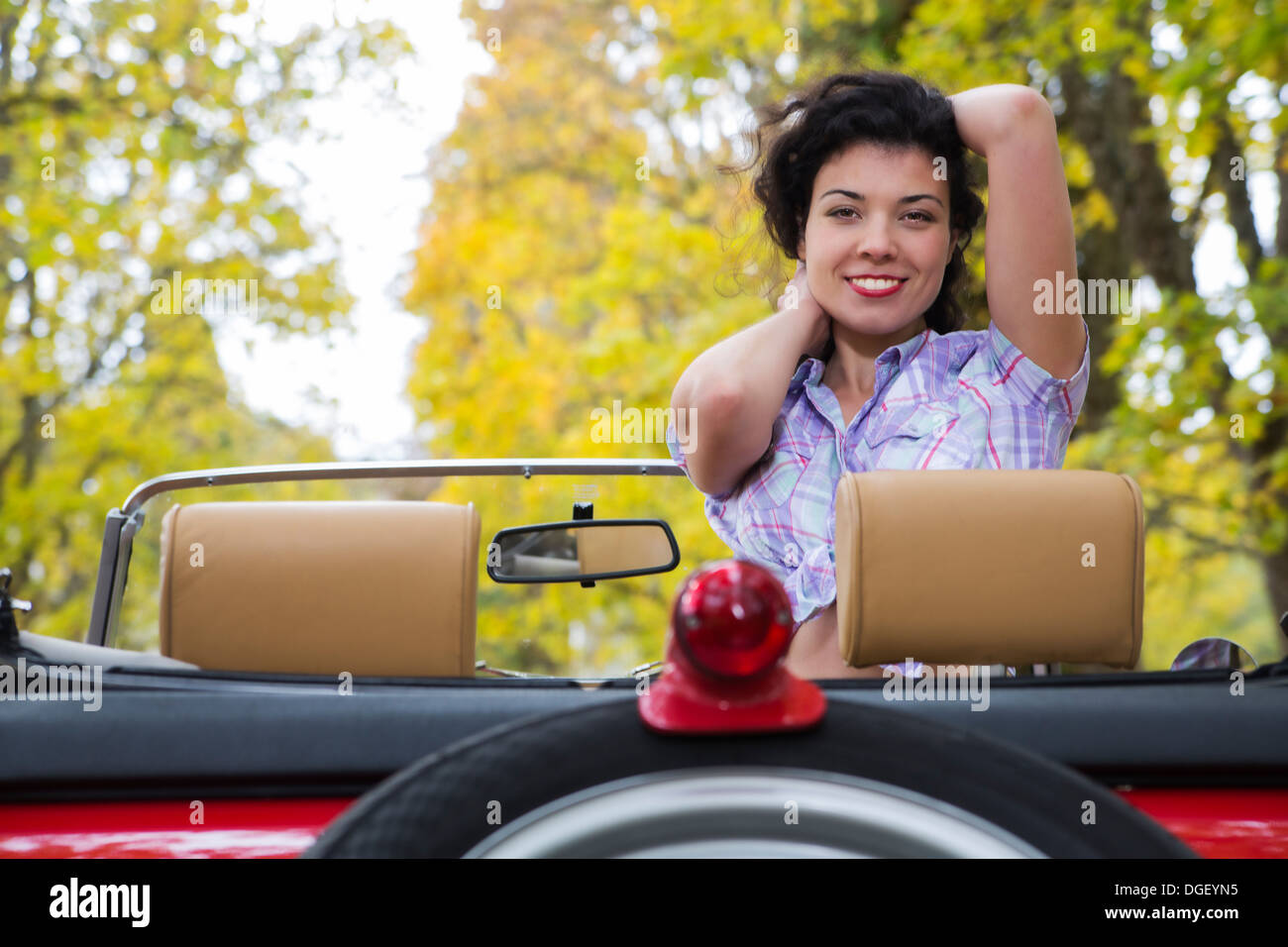 Erstaunliche Frau mit breiten Lächeln auf Retro-Auto Stockfoto